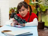 Child holding LEGO F1 car.