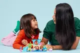 Child and adult playing with LEGO Gabby's Dollhouse.