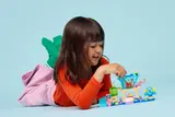 Child playing intently with LEGO Gabby's Dollhouse.