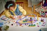 Child building LEGO Mermaid Roller Coaster from above.
