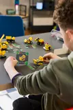 Child interacting with Technic model and game card.