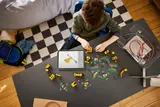 Child building LEGO Technic with tablet.