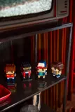BrickHeadz on a reflective shelf.