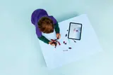 Child building LEGO mech using tablet.