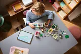 Girl building the castle with tablet.