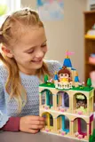 Girl placing Belle on castle balcony.