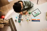 Overhead view of building process with digital instructions.