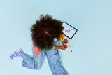 Child building LEGO with digital instructions.