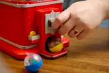 Hand dispensing capsule from machine.