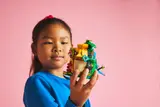Child holding yellow island hut.