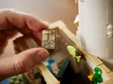 Hand holding tiny lighthouse picture.