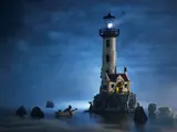 Lighthouse light shining through fog at night.