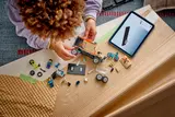 Child building LEGO van with tablet.