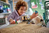 Child playing with LEGO van set.