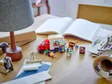 LEGO Moving Truck set 40586 on a wooden desk with real-life items.