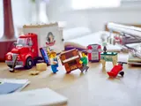 Close-up of minifigures moving a piano from LEGO Moving Truck set.
