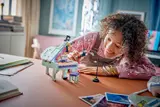 Smiling person building LEGO.