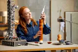 Woman holding rocket top section.