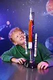 Boy smiling at LEGO Artemis rocket.
