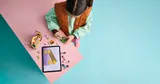 Child building LEGO with digital instructions.