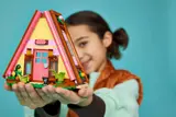 Girl holding closed LEGO Glamping Cabin.