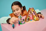 Girl playing with LEGO Glamping Cabin and minifigures.