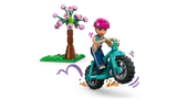 Liann on bike, mid-jump near a tree.