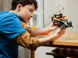 Child holding McLaren Formula E car.
