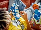 Builder customizing LEGO Nike Dunk shoe straps.