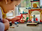 Child playing with Kai and Lloyd minifigures.