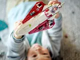 Child holding starfighter from above.