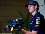 Max Verstappen holding RB20 model.