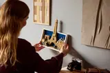 Woman placing LEGO Paris on wall.