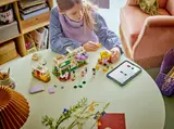 Child building LEGO botanical set.