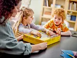 Family opening LEGO Braille Bricks box.