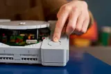 Hand pressing PlayStation button.