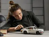 Woman adjusting LEGO Porsche 911 Turbo.