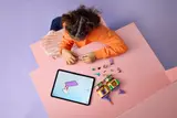 Child building with tablet instructions.