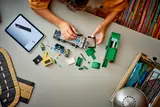 Overhead view of child building LEGO truck chassis with iPad.