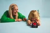 Child and adult playing with LEGO tractor.