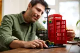Man opening LEGO telephone box door.