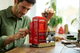 Man adjusting LEGO street lamp.