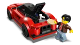 Kai polishing the rear of the red LEGO sports car with open trunk.