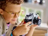 Child holding LEGO camera.