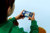 Child's hands playing LEGO console.