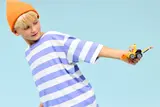 Child holding LEGO loader playfully.