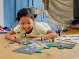 Child smiling while building LEGO roads.