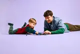 Father and son playing with LEGO Ninjago cars.