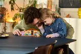 Father and daughter bonding over LEGO Bluey.