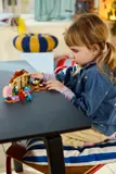 Girl building LEGO Bluey house.